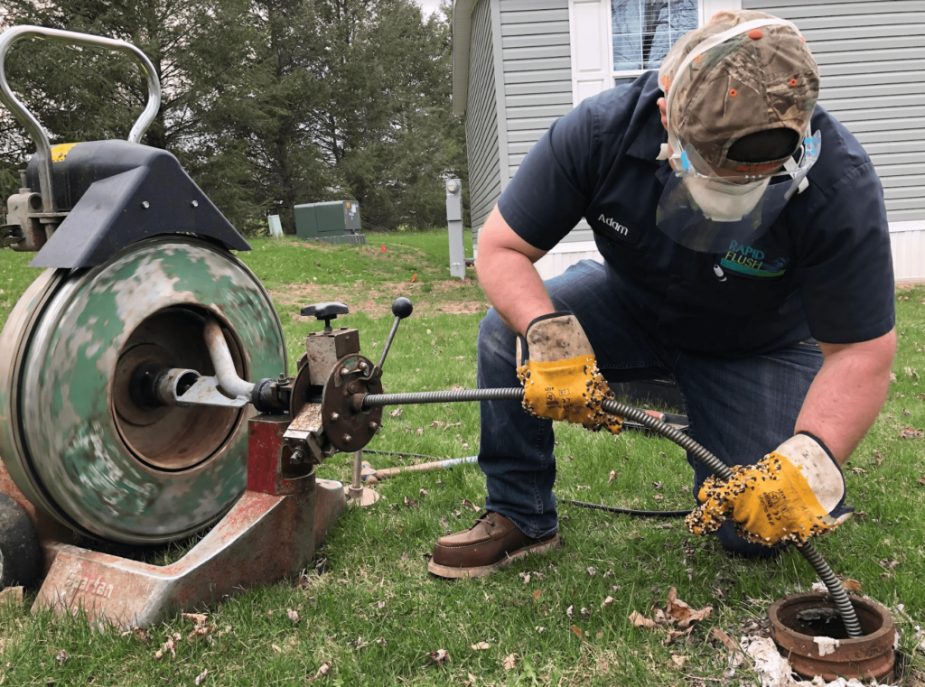 Opening a clogged sewer line from an outside clean out with a cable machine