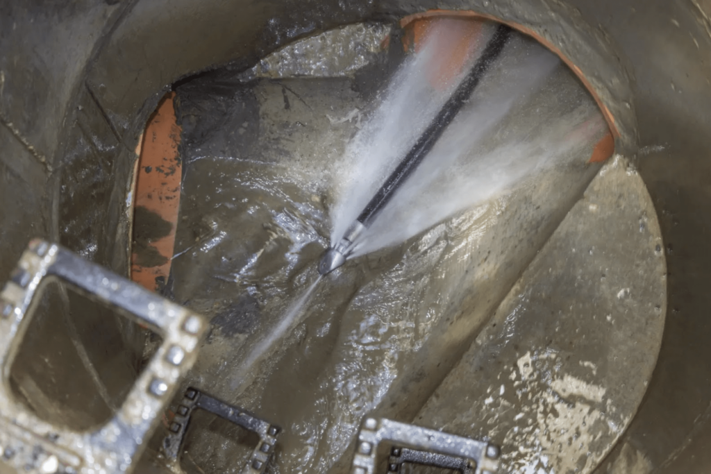 Nozzle cleaning a storm drain using a high pressure hydro-jet