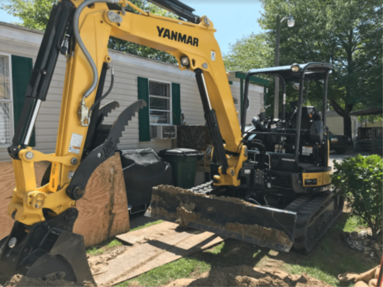 An excavator digging up a pipe to be replaced.